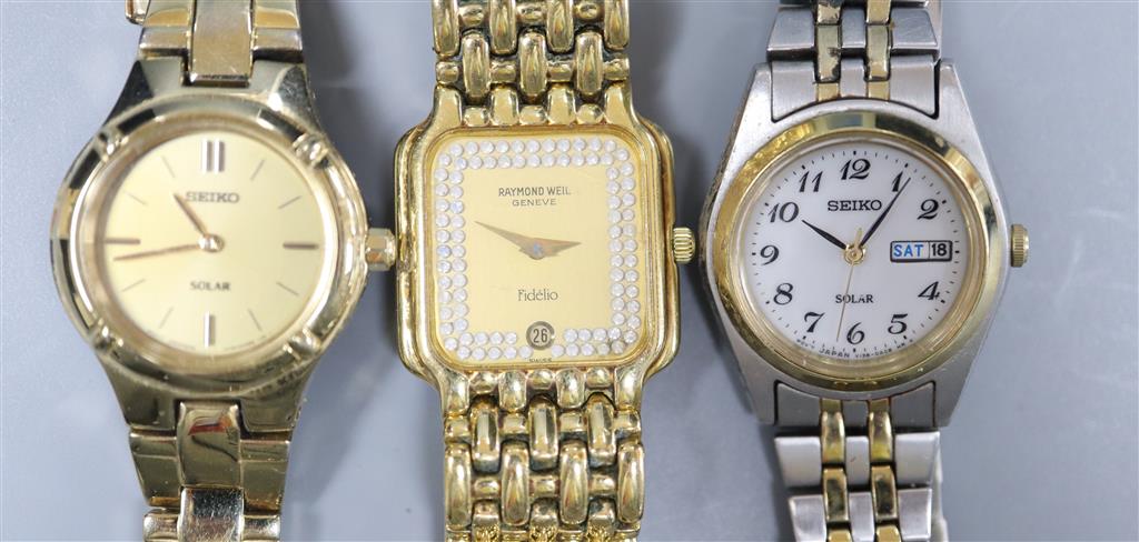 A ladys Raymond Weil gilt metal wrist watch and two Seiko wrist watches.